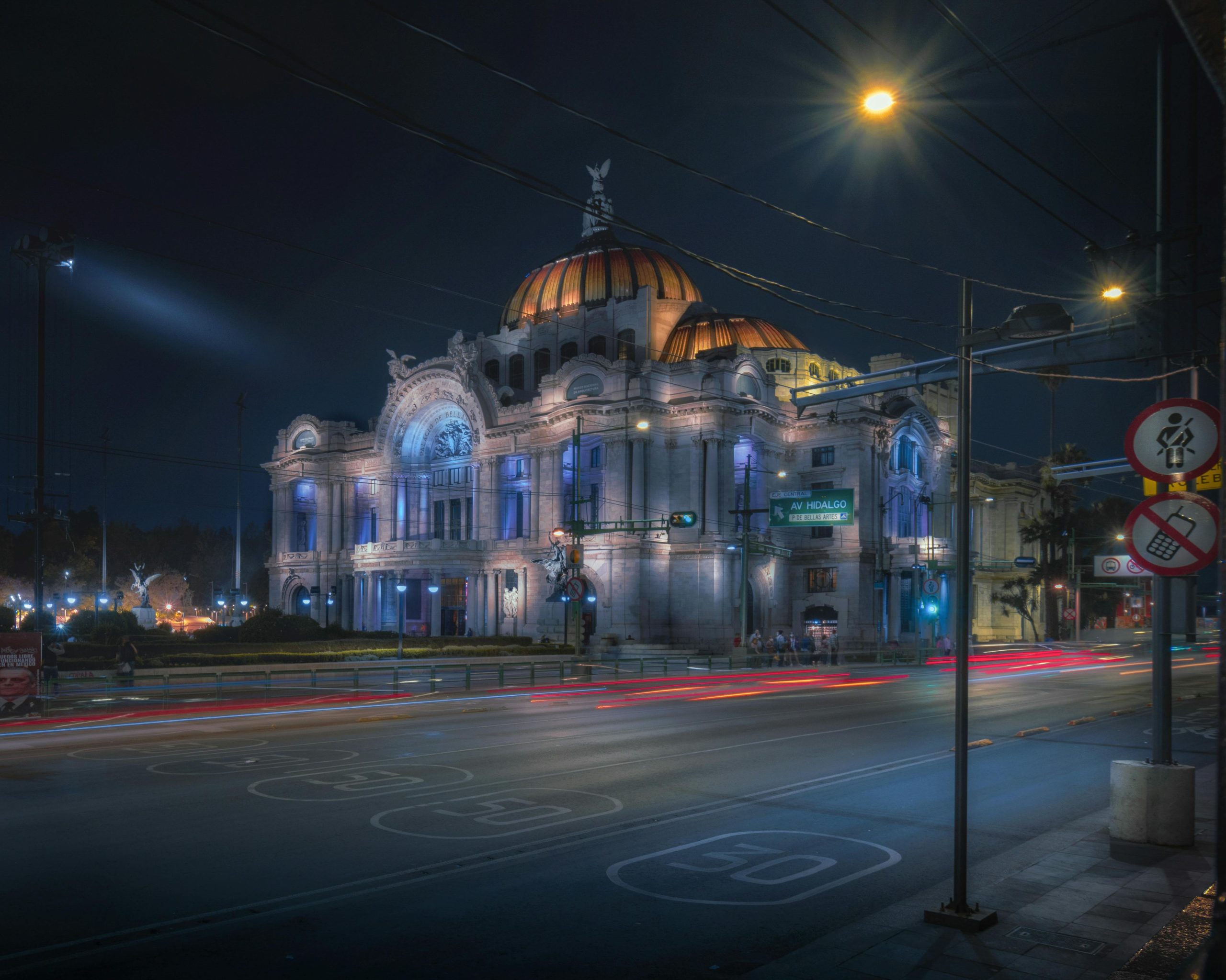 Stunning nighttime image of the illuminated Palacio de Bellas Artes, a cultural landmark in Mexico City.