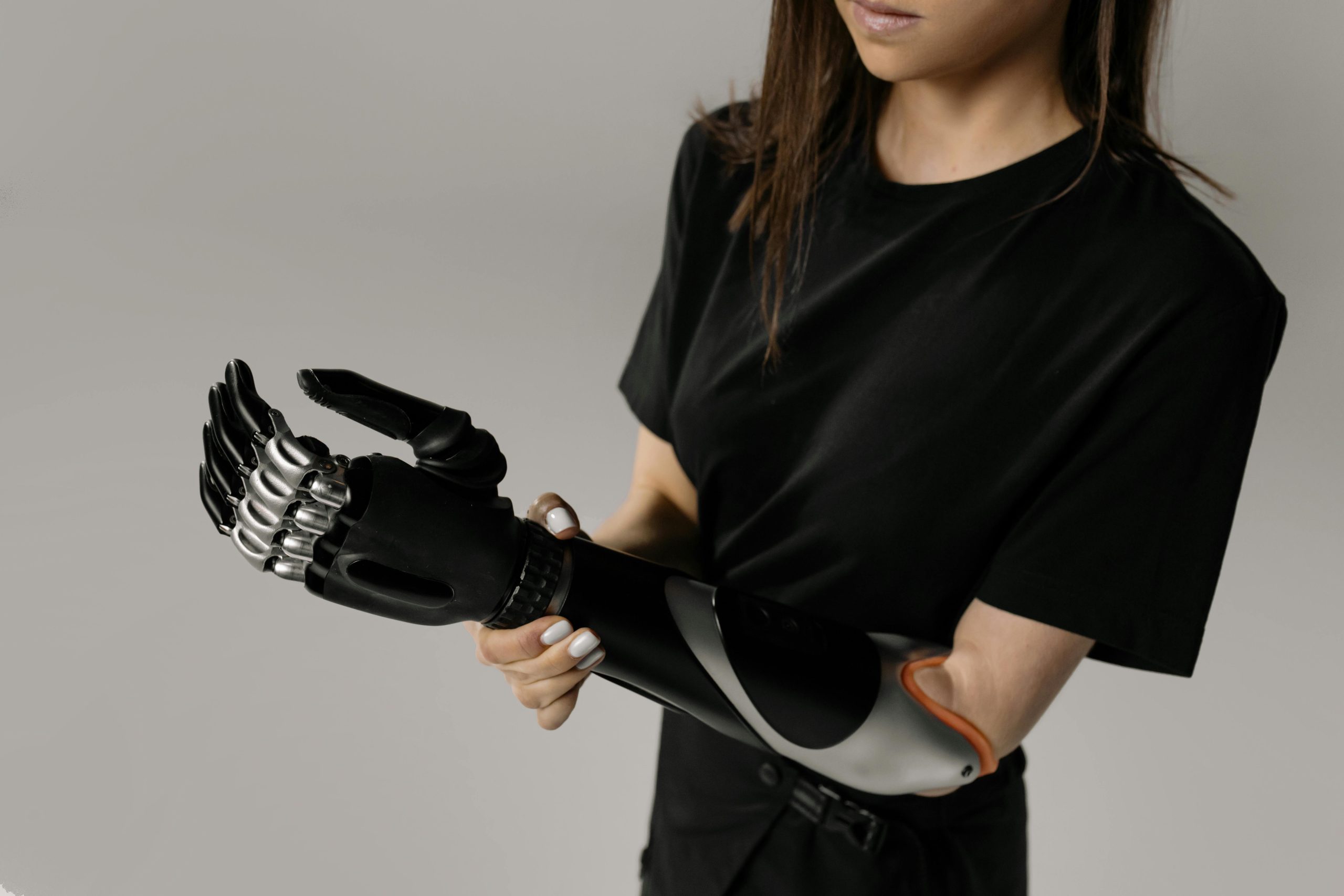 Close-up of a woman adjusting her cutting-edge bionic prosthetic arm, showcasing innovation.