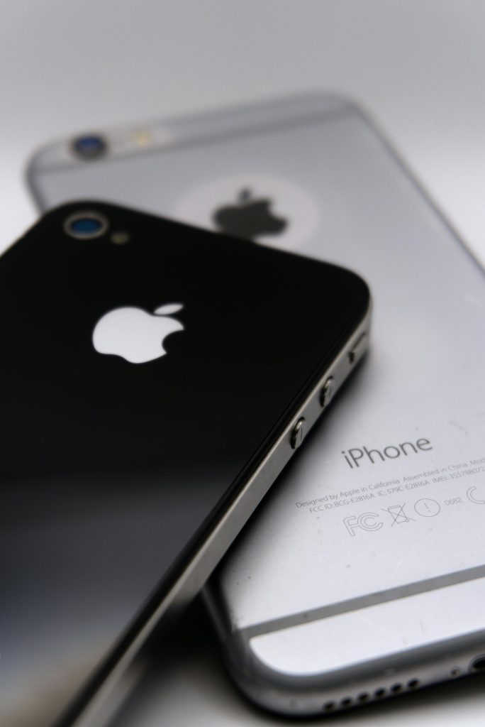 Radiografía del consumo omnicanal: el comercio electrónico equilibra la alta tecnología con el abastecimiento doméstico Detailed shot of two smartphones featuring the Apple logo, showcasing modern technology design.