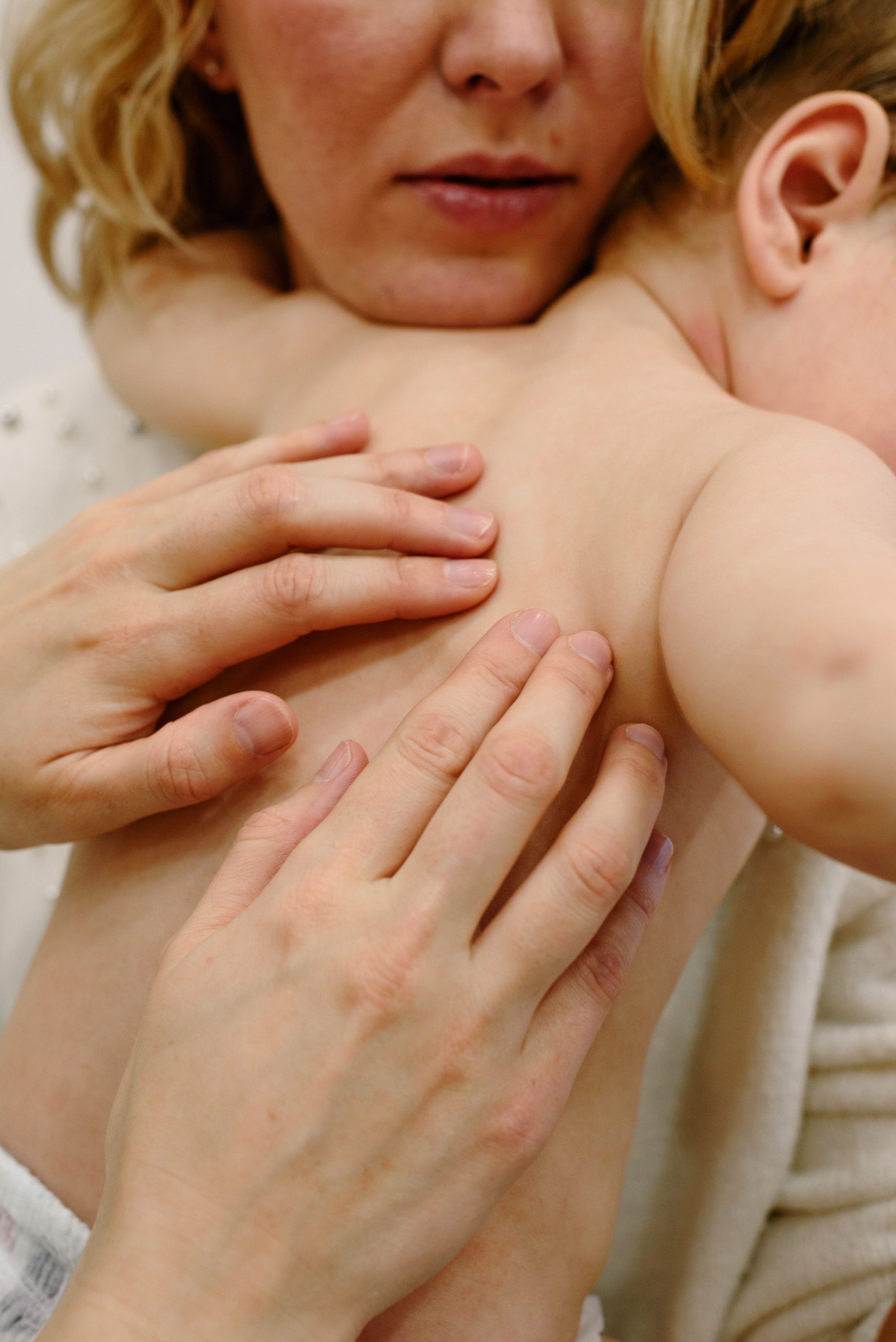 Close-up of a mother giving a gentle massage to her baby, showcasing tender care.