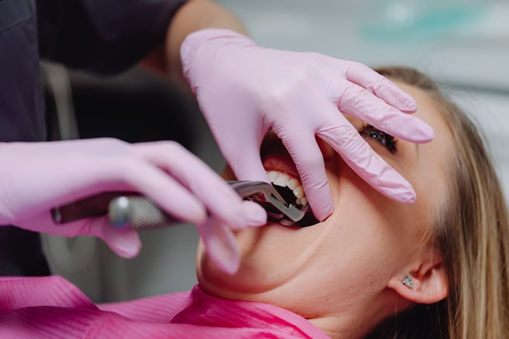 Especialista en odontología examinando la salud bucal y articulación mandibular de un paciente en clínica dental