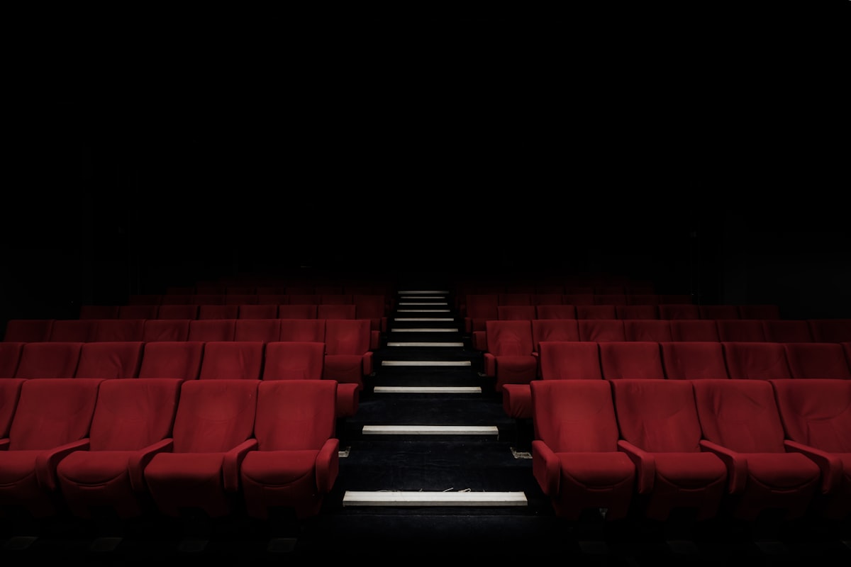 Proyección cinematográfica en pantalla panorámica de sala de cine comercial
