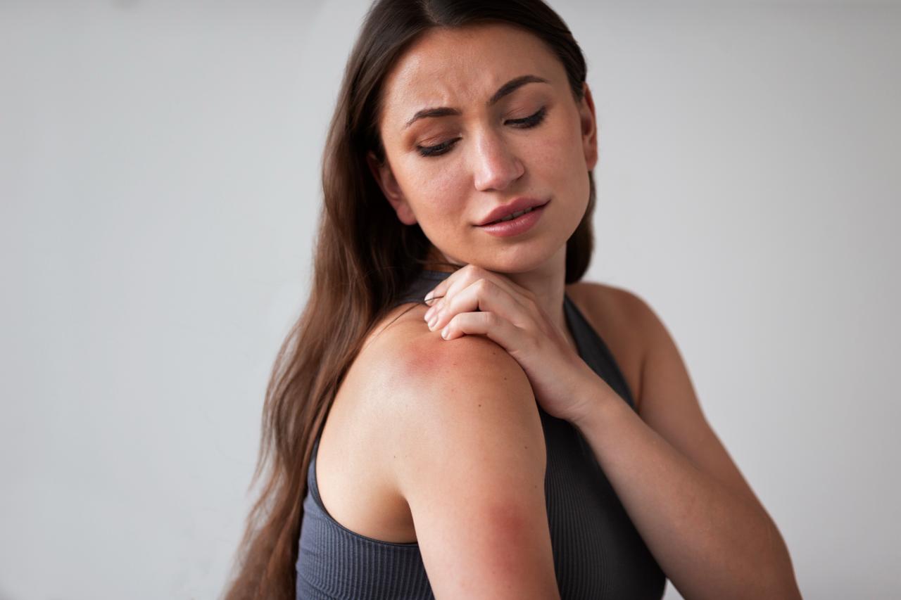 Especialista médica examinando afección dermatológica en paciente durante consulta clínica