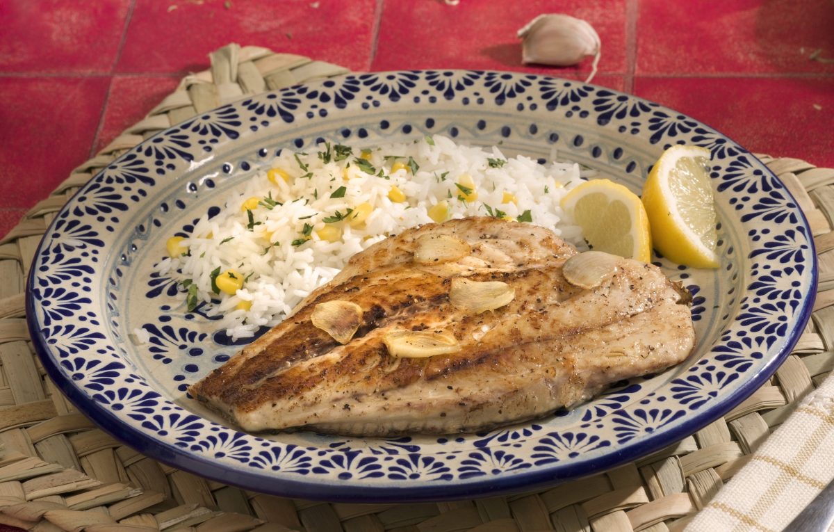 Platillo tradicional de pescado huachinango a la veracruzana servido con salsa de jitomate, aceitunas y alcaparras