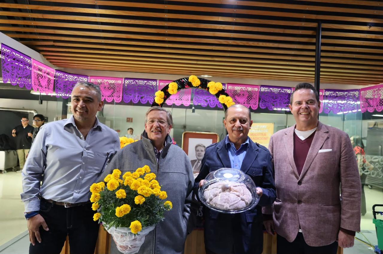 Pan de muerto tradicional mexicano con azúcar junto a flores de cempasúchil en ofrenda