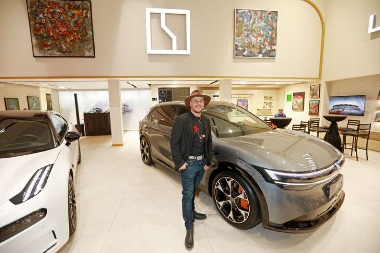 Exposición de arte contemporáneo y diseño automotriz en espacio de exhibición cultural