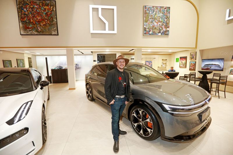 Exposición de arte contemporáneo y diseño automotriz en espacio de exhibición cultural
