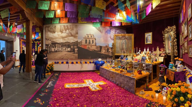 Altar monumental de Día de Muertos con cartonería tradicional y flores de cempasúchil en recinto museístico de San Ángel